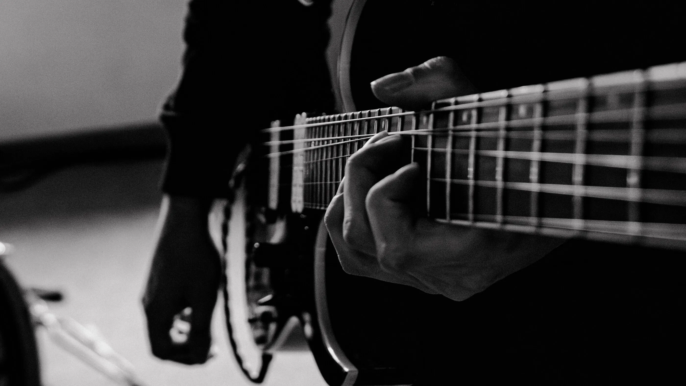 Schwarz-Weiß-Aufnahme einer Hand auf dem Griffbrett einer E-Gitarre